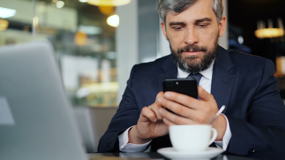 a man sitting at a table looking at his cell phone