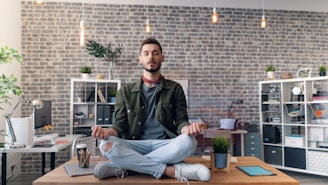 a man sitting in the middle of a room doing yoga