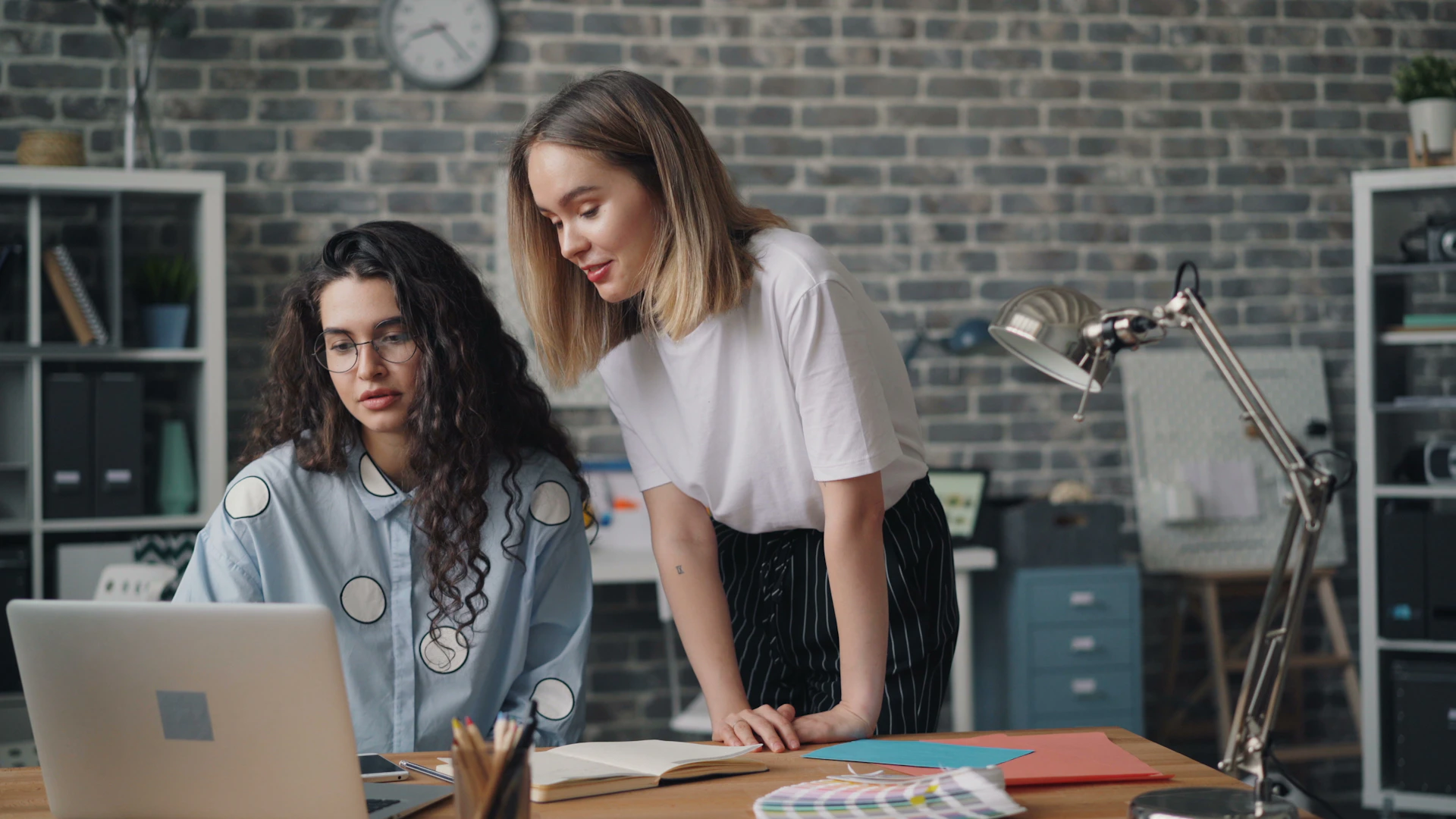 two women in an office looking at a laptop