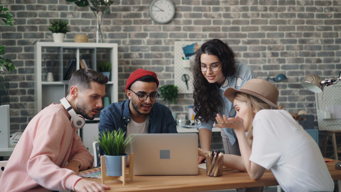 Small team working together at a laptop — the kind of operating team CampaignCNX+, Alma, and Beacon are built for