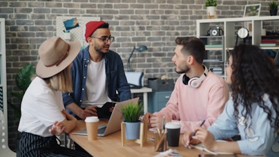 a group of people sitting around a wooden table