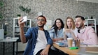 a group of people sitting around a wooden table