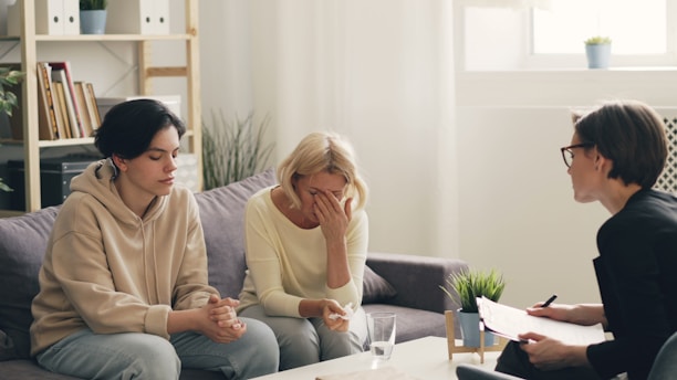 two women sitting on a couch talking to each other