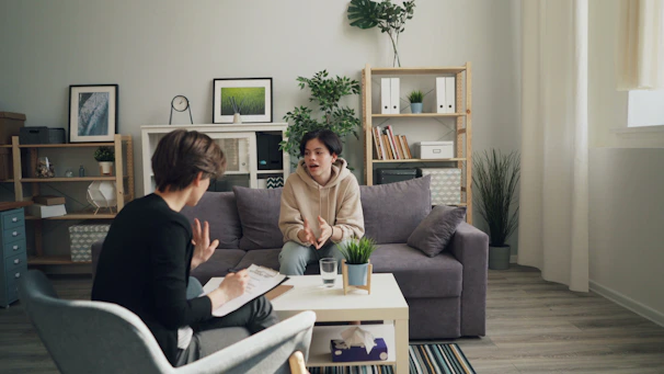 two women sitting on a couch in a living room