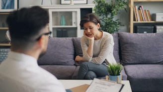 a woman sitting on a couch talking to a man