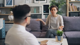a woman sitting on a couch talking to a man