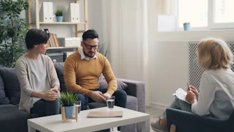 a man and woman sitting on a couch talking to each other