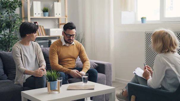 a man and woman sitting on a couch talking to each other