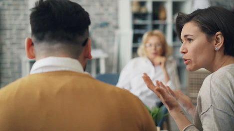 a woman talking to a man at a table