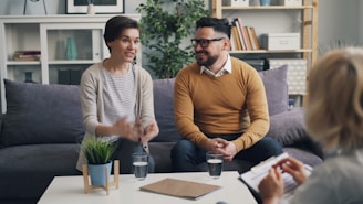 a man and woman sitting on a couch talking to each other