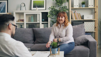 a woman sitting on a couch talking to a man