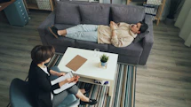 a man and woman sitting on a couch in a living room