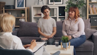 two women sitting on a couch talking to each other