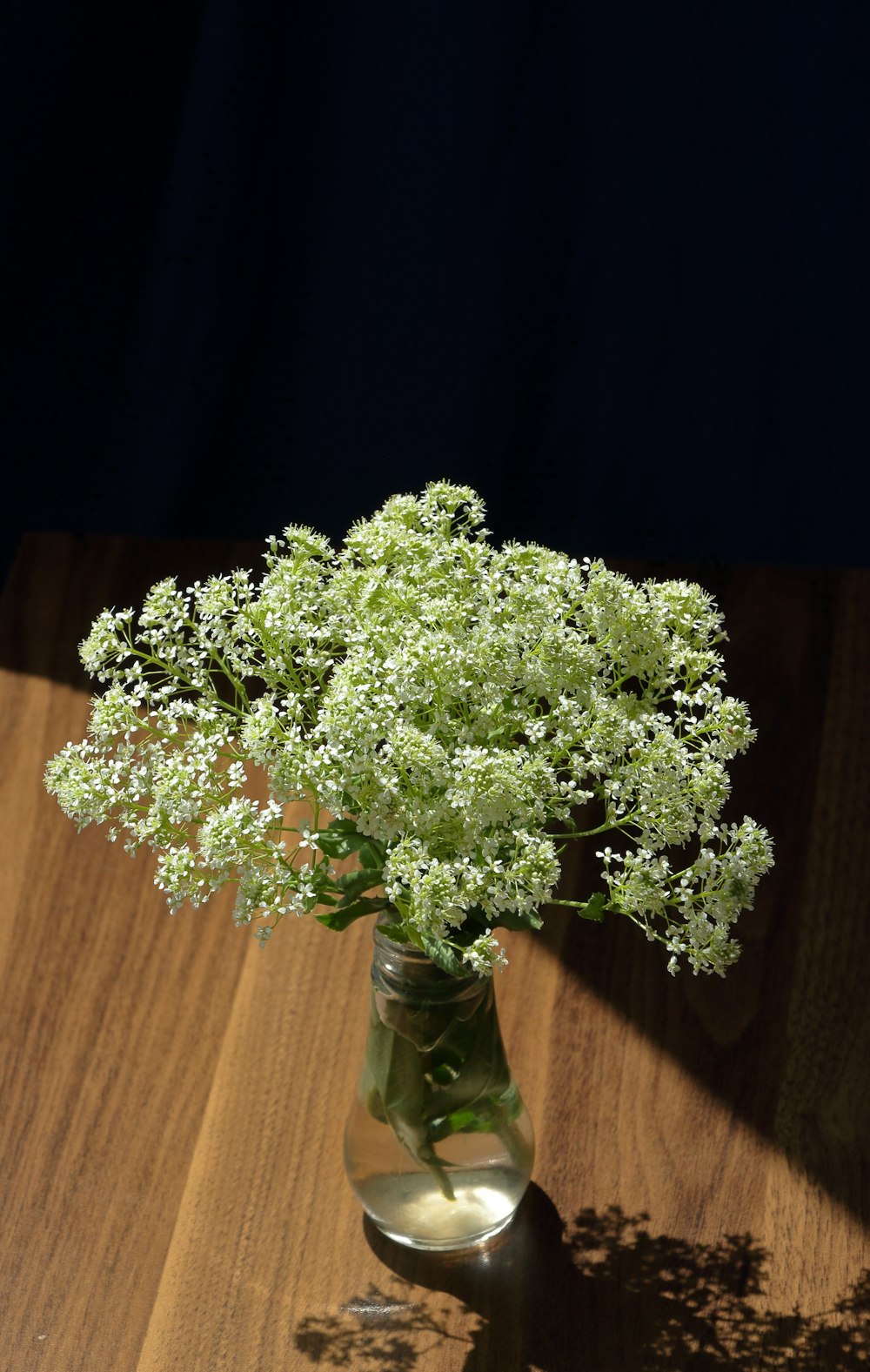 a vase filled with flowers on top of a wooden table