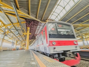 a red and white train pulling into a train station