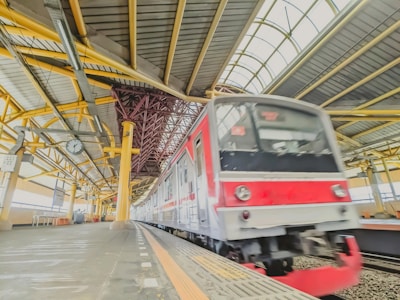 a red and white train pulling into a train station