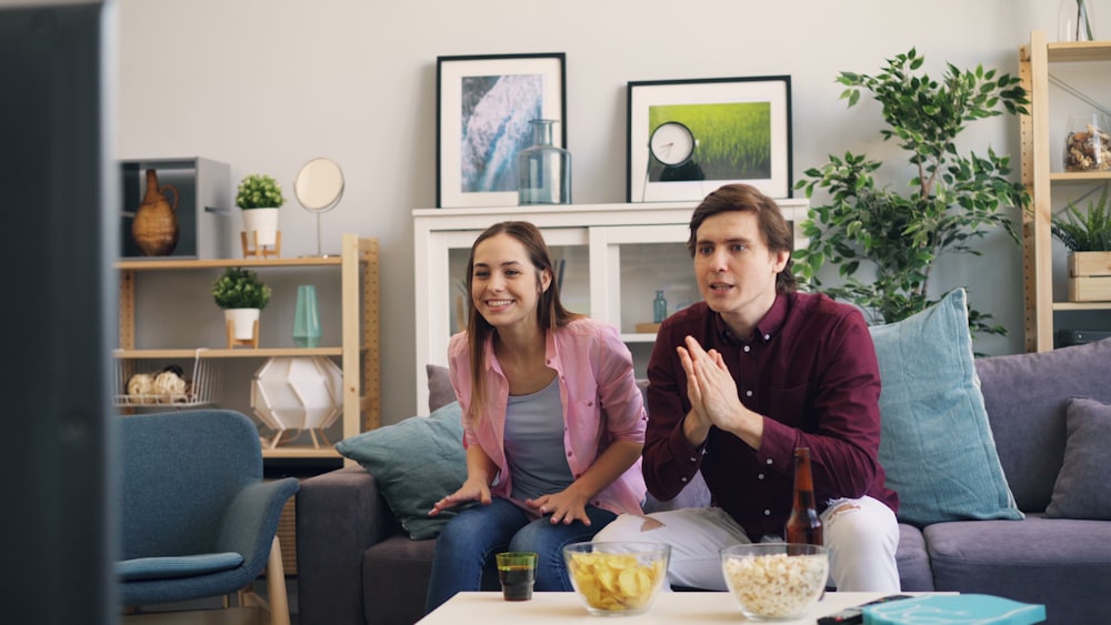 a man and woman sitting on a couch in a living room