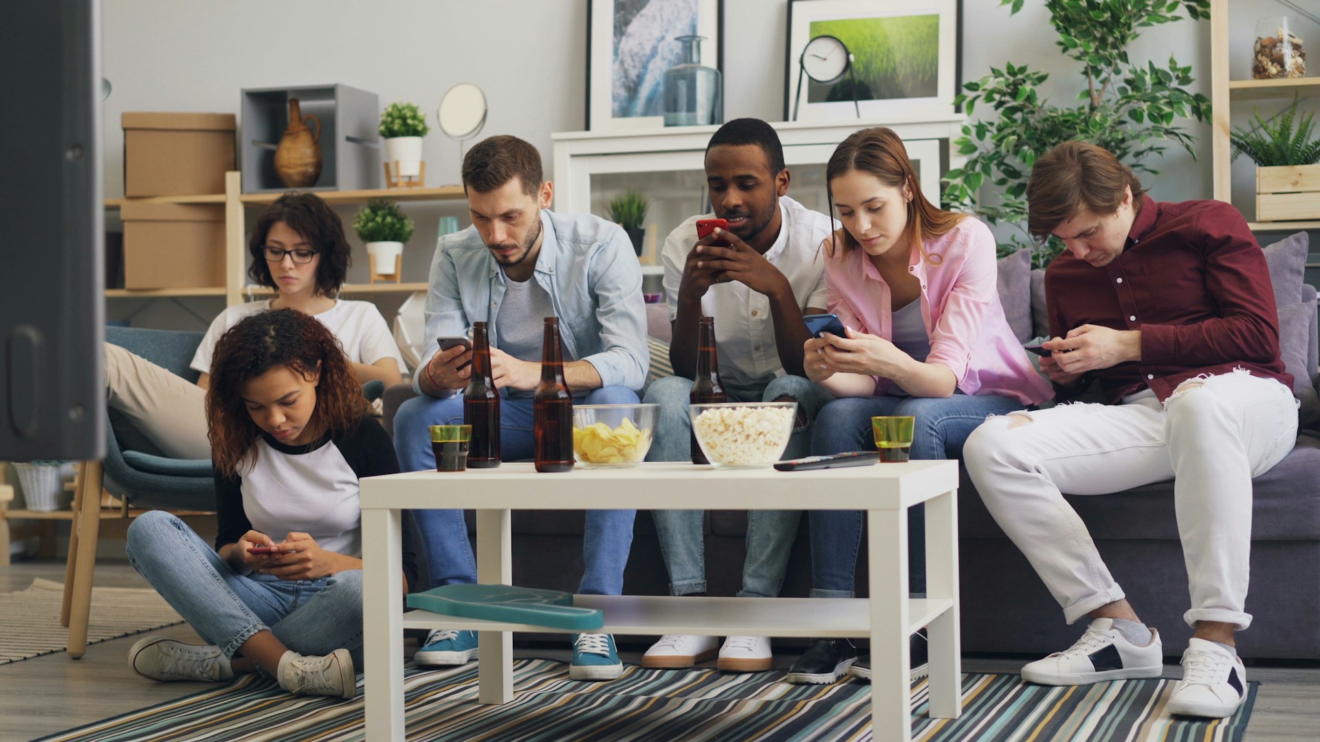 a group of people sitting on a couch looking at their phones