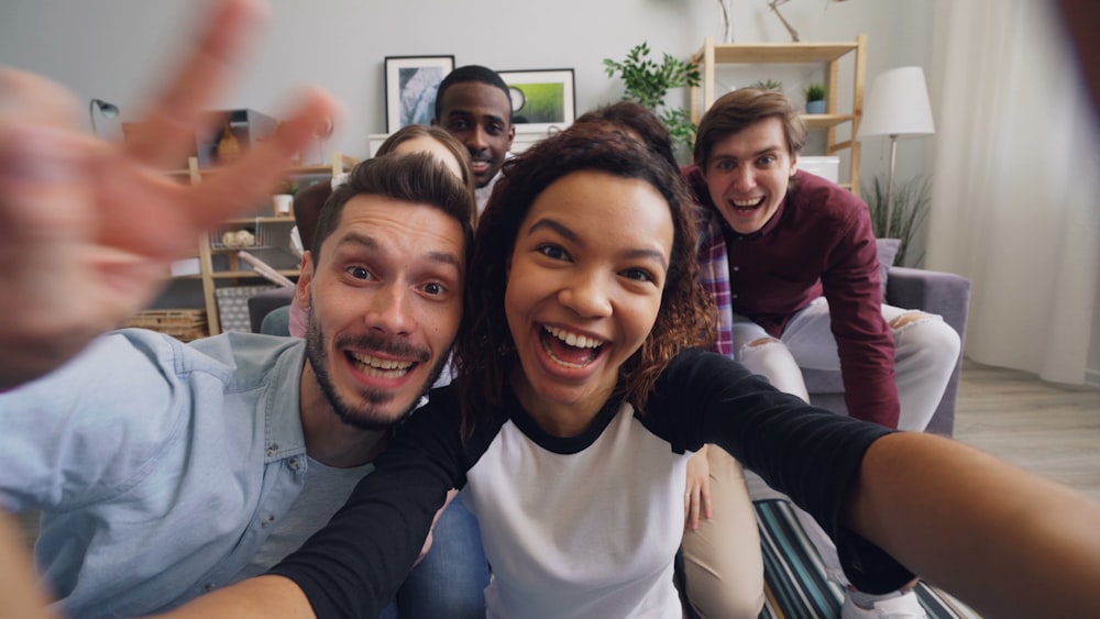 a group of friends taking a selfie in a living room