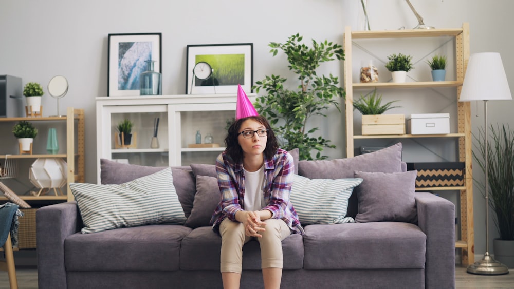 a woman wearing a birthday hat sitting on a couch