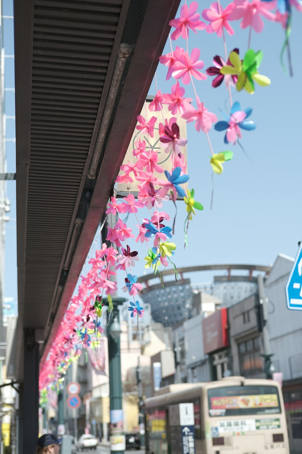 a group of colorful paper flowers hanging from a building