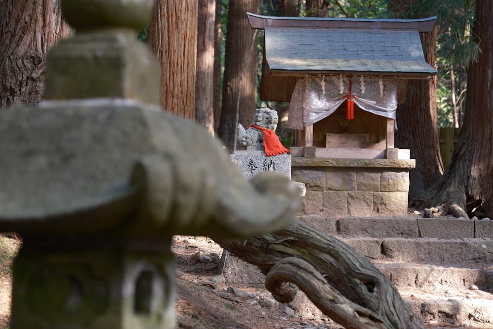 a statue in the middle of a forest with a pagoda in the background