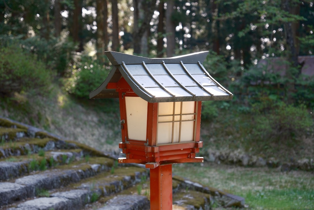 a small red lantern sitting on top of a wooden pole