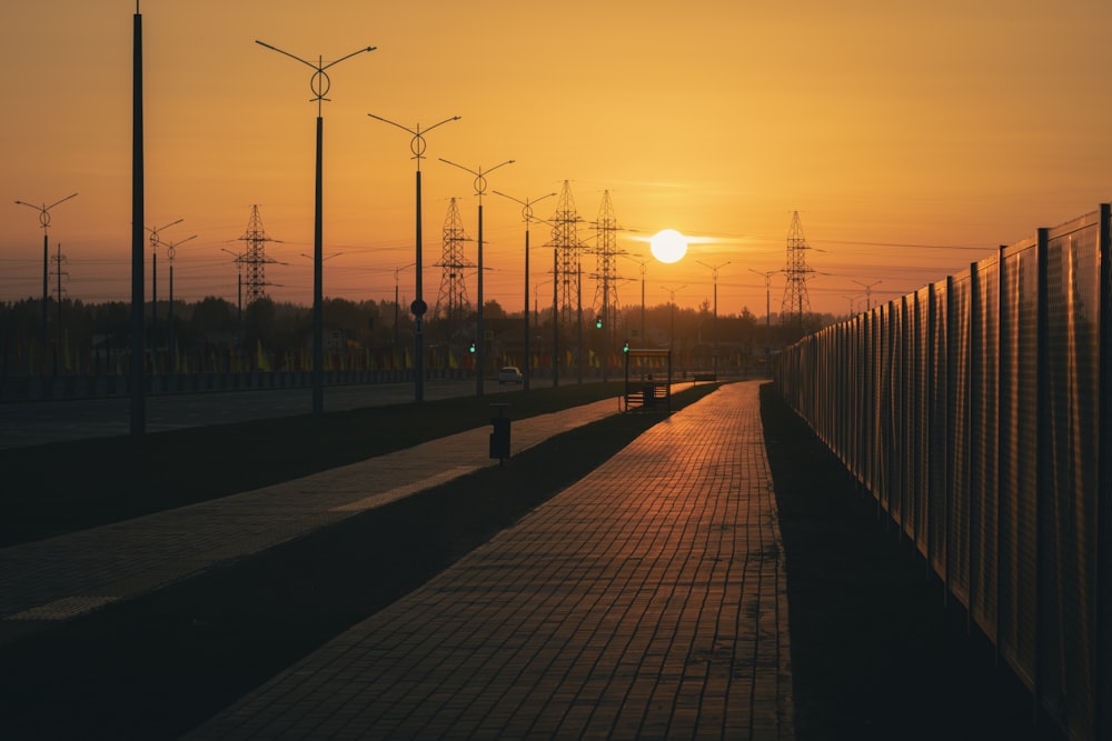 the sun is setting behind a row of power poles