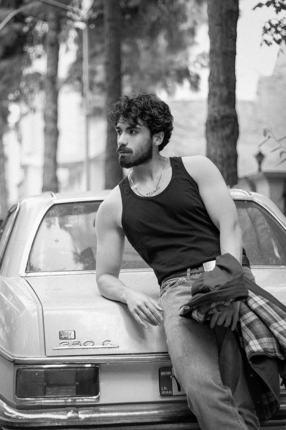 a man leaning on the hood of a car