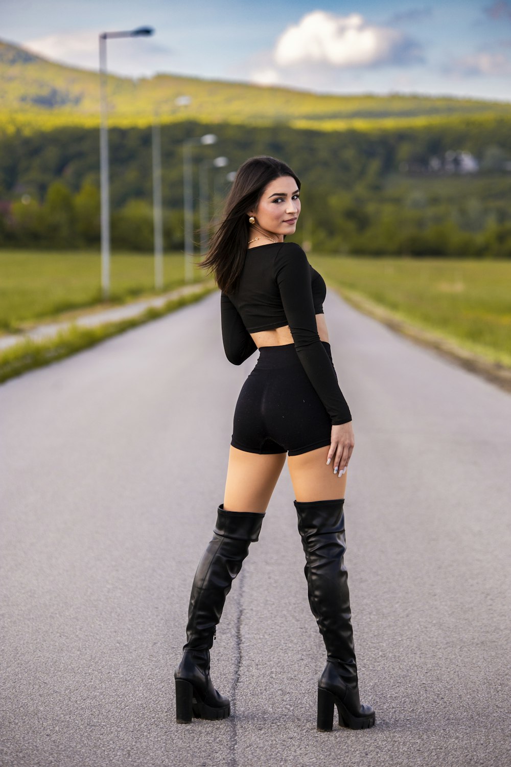 a woman in a short skirt and boots posing for a picture