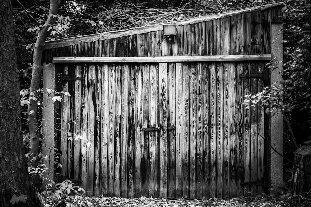 a black and white photo of an old outhouse