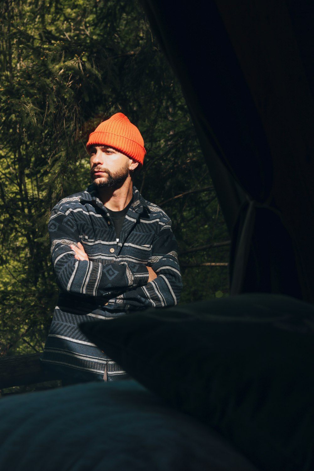 a man wearing a hat standing in front of a tent