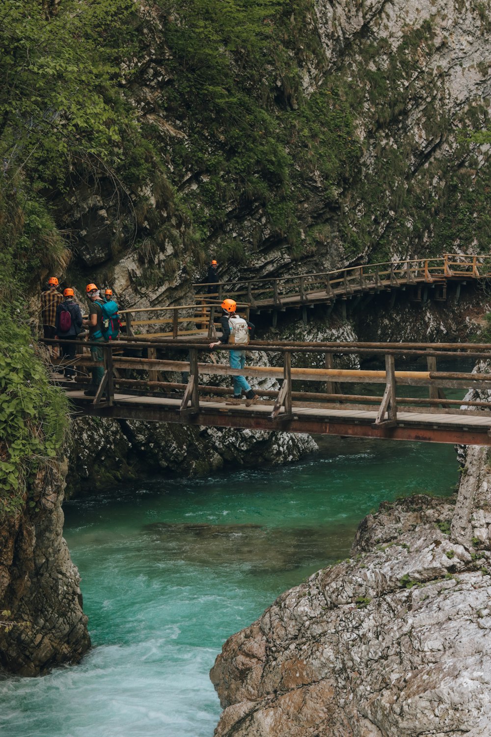 un gruppo di persone in piedi su un ponte su un fiume