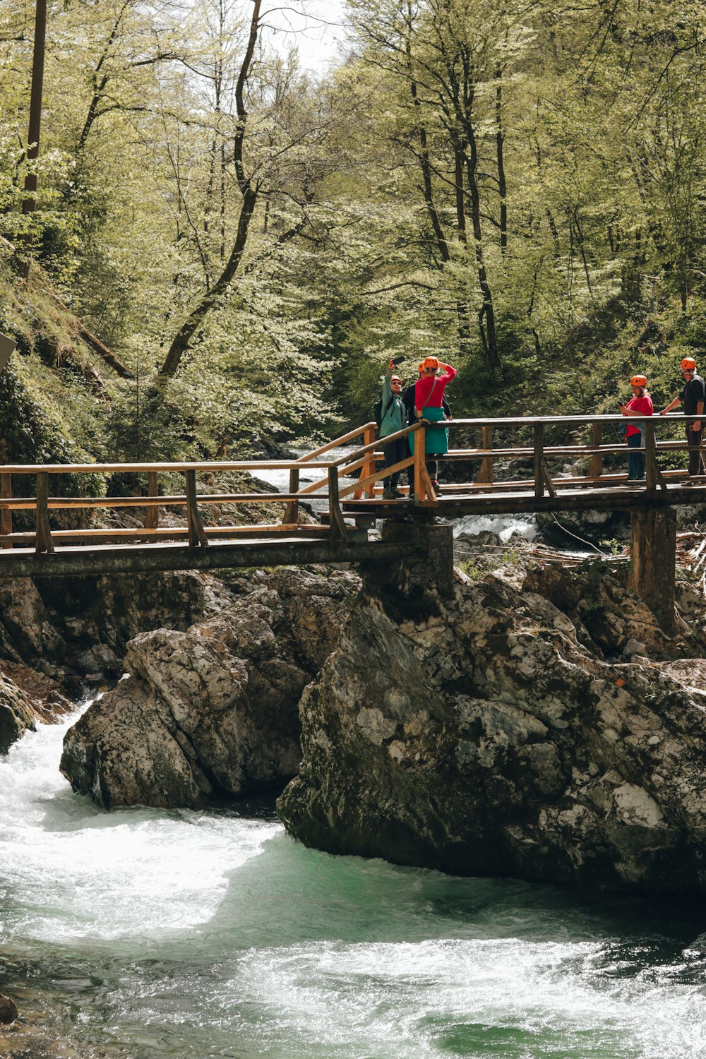 a group of people standing on a bridge over a river