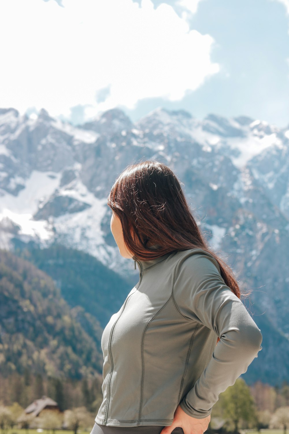 a woman standing in front of a mountain