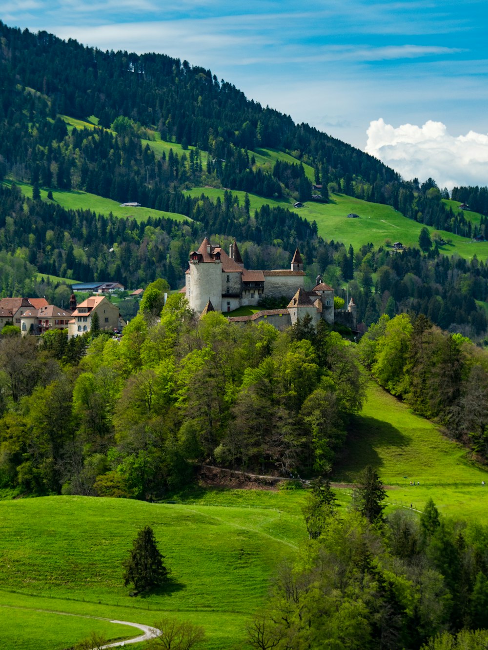 a green hillside with a large building on top of it