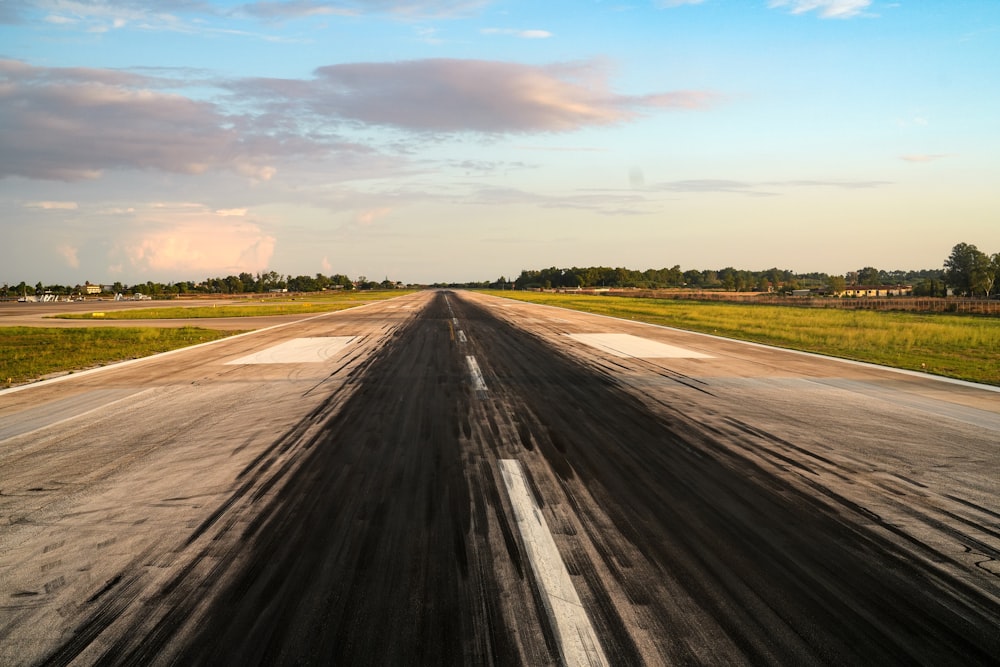an empty runway with a sky in the background