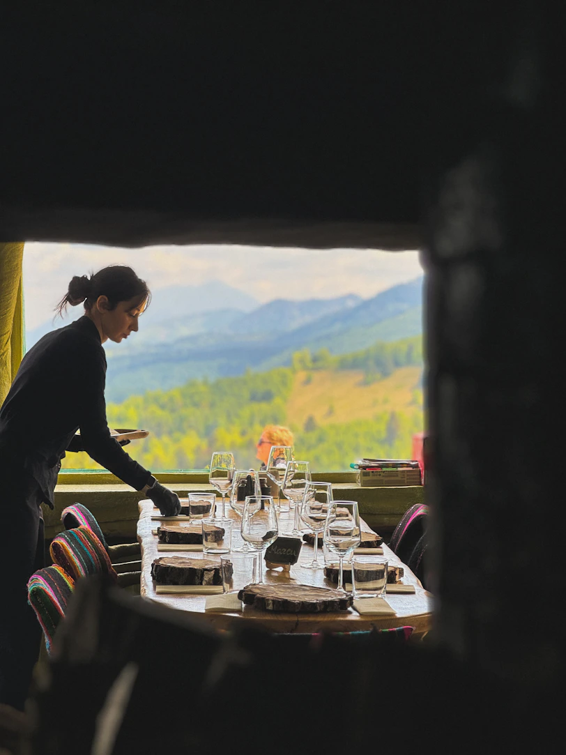 A server sets a table with a mountain view