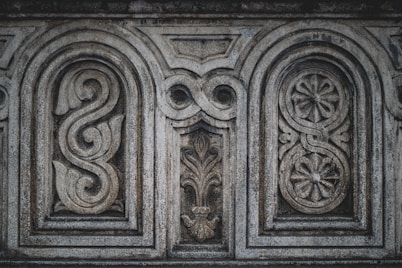 a close up of a stone wall with carvings on it