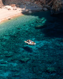 a couple of people in a small boat on a body of water