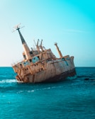 an old rusted ship in the middle of the ocean