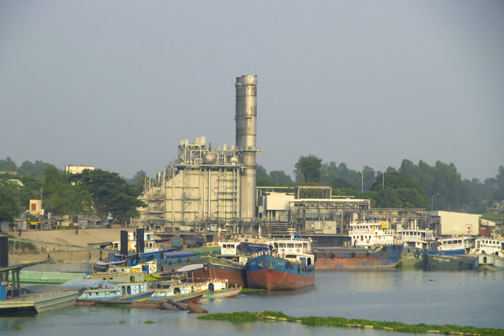 a harbor filled with lots of boats next to a factory