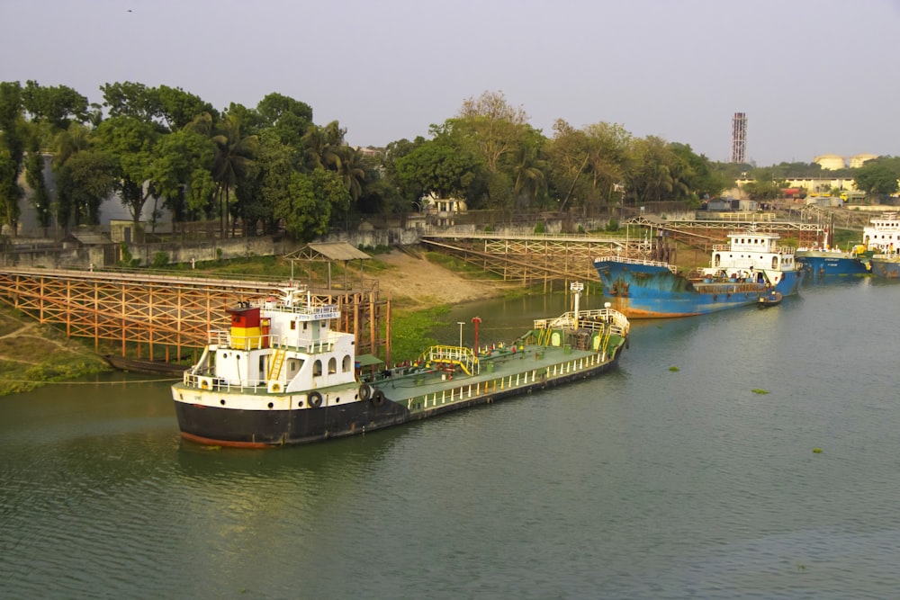 a river filled with lots of boats next to a forest