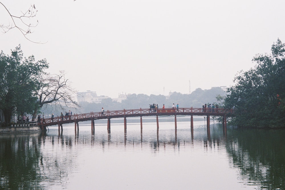 a group of people standing on a bridge over a body of water