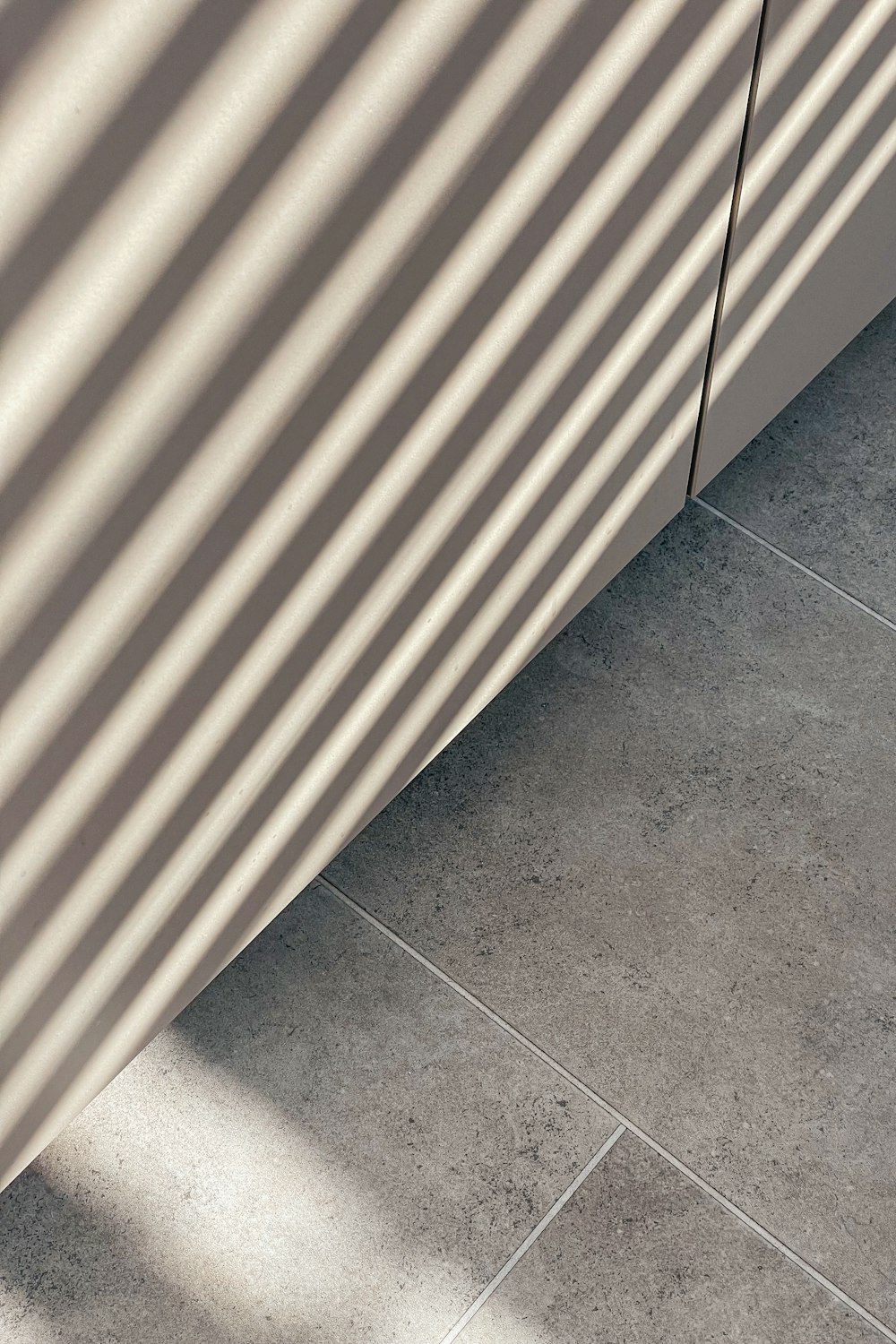 a close up of a tile floor with a wall in the background