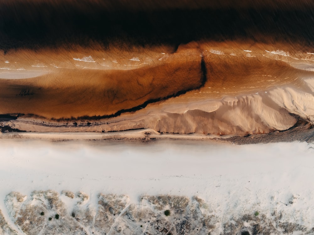 an aerial view of a sandy beach and a body of water