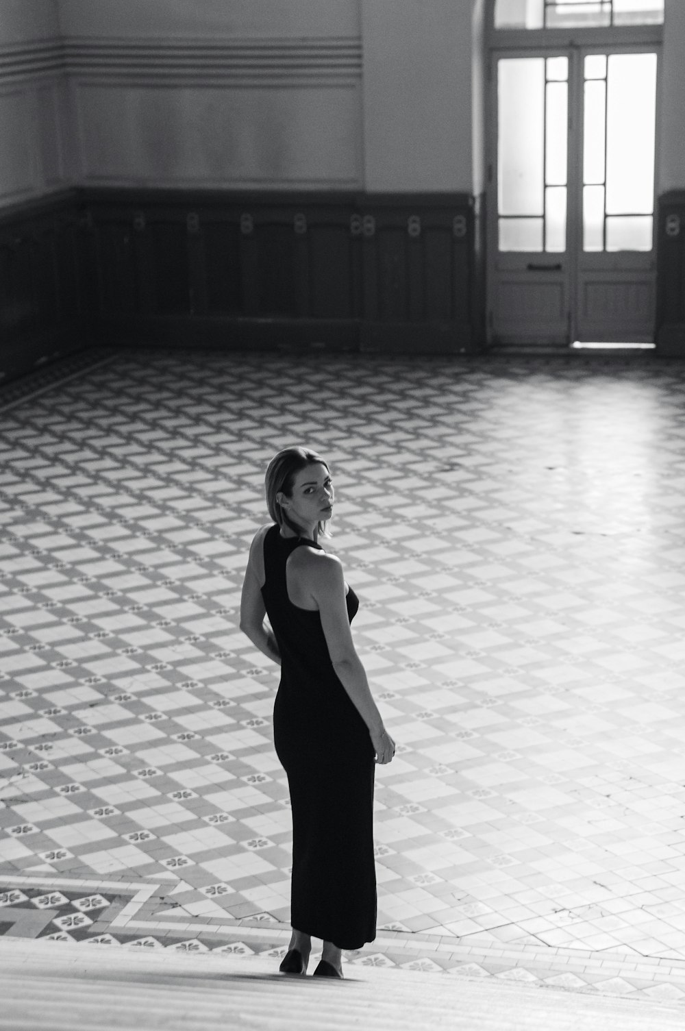 a woman in a black dress standing in a room