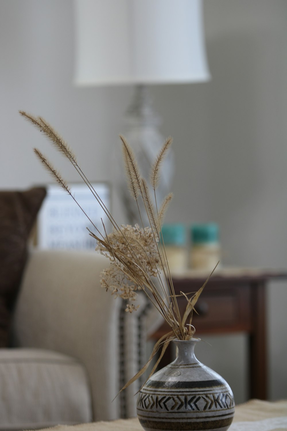 a vase sitting on top of a table next to a lamp