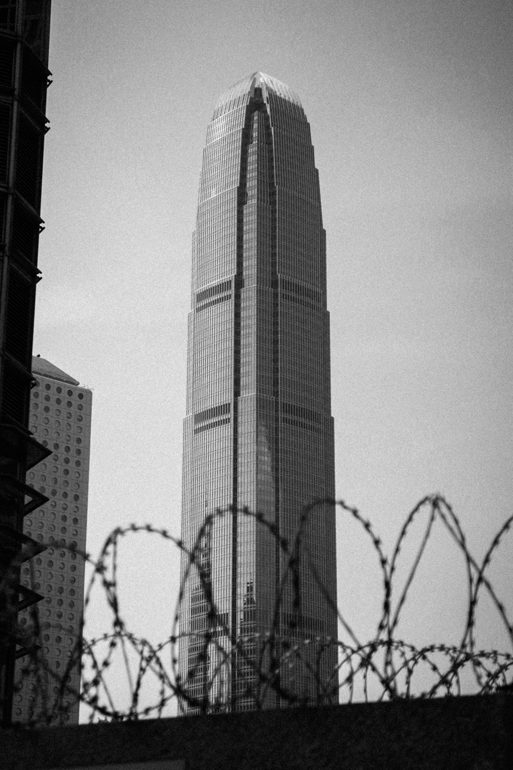 a tall building behind a barbed wire fence