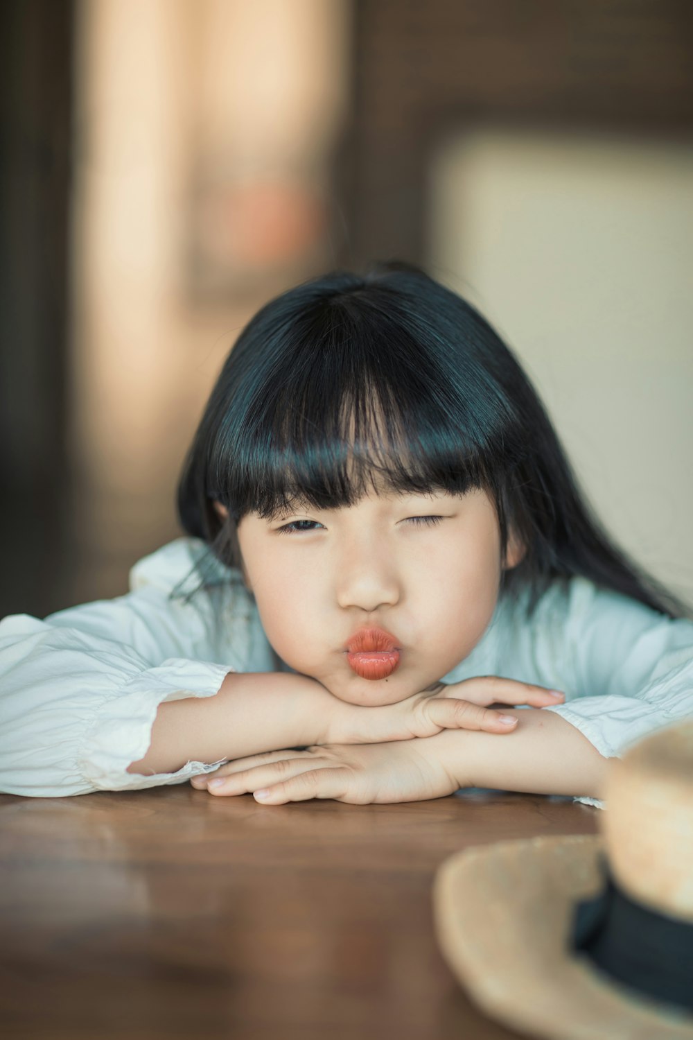 a little girl laying her head on a table